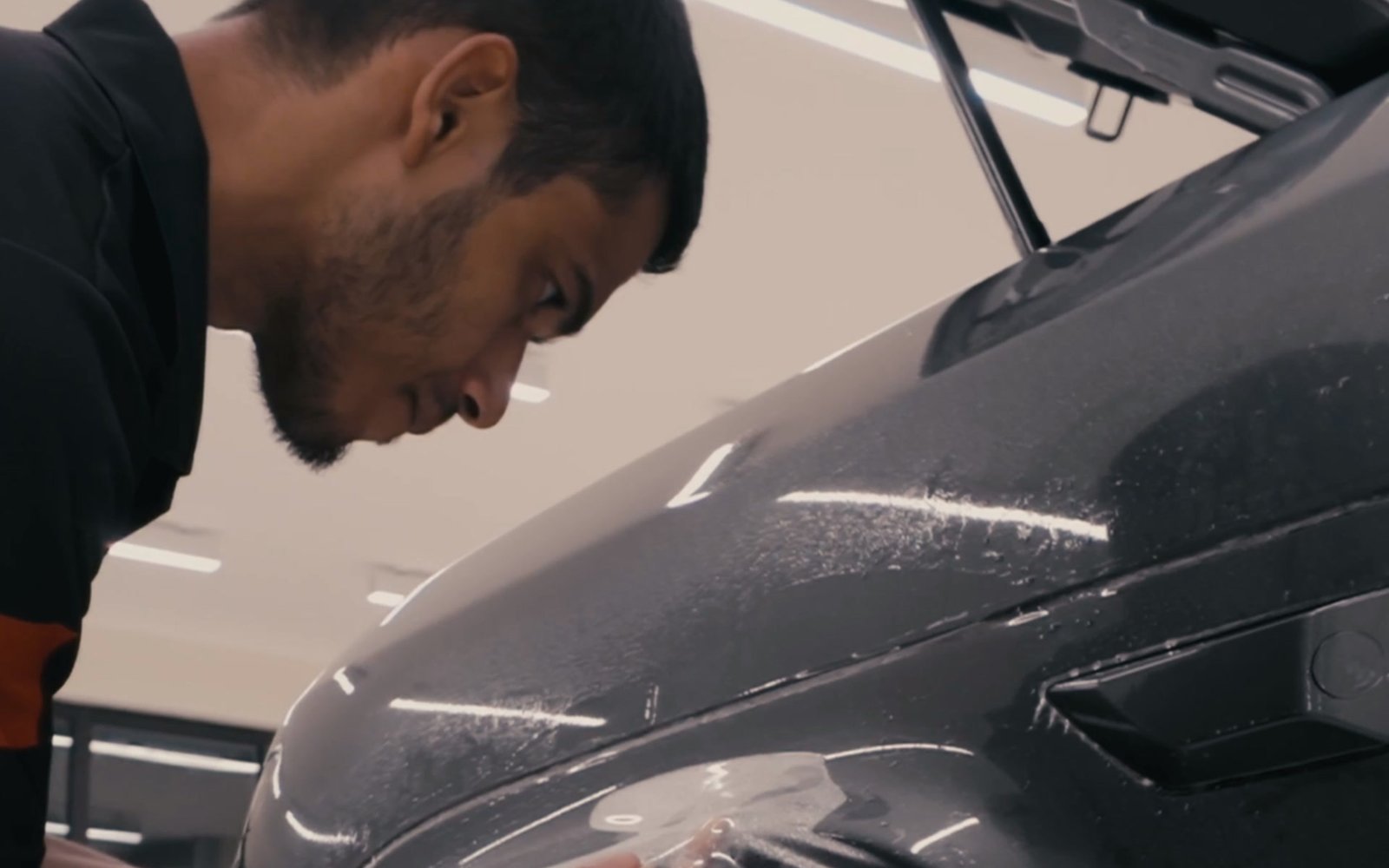 Smart Shield installer applying paint protection film to a car fender